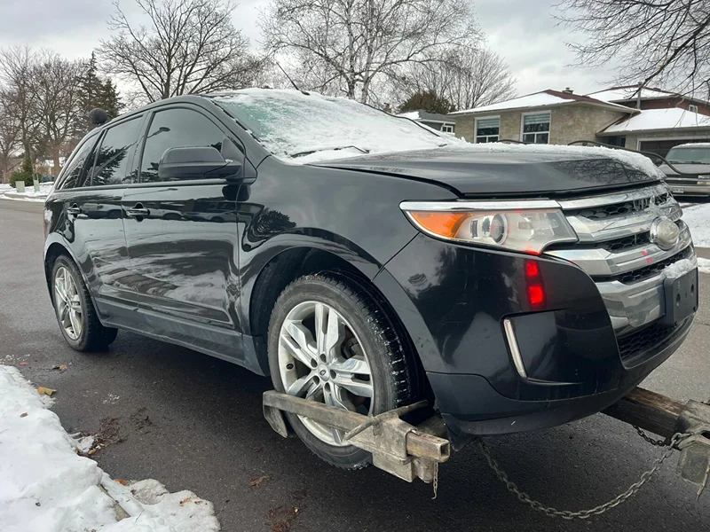 Scrap car removal in Vaughan: end-of-life SUV being towed from a driveway